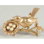 A SMALL 9CT GOLD AND PEARL BIRD, WITH A NEST BROOCH.