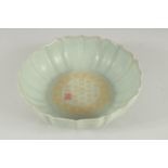 A CHINESE PETAL SHAPE CELADON BOWL, the interior with characters. 21cm diameter.