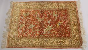 A VERY GOOD PERSIAN SILK HUNTING RUG red ground with figures of huntsmen on horseback, animals and