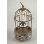 A SMALL CLOISONNE SINGING BIRD in a cage. 7ins high.
