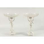 A SUPERB PAIR OF CUT GLASS AND SILVER PLATED TAZZA with glass bowls held aloft by cupids. 14ins high