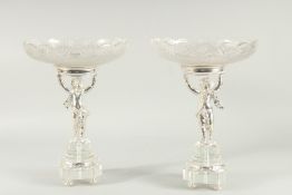 A SUPERB PAIR OF CUT GLASS AND SILVER PLATED TAZZA with glass bowls held aloft by cupids. 14ins high