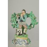 A PRATT WARE BOCAGE GROUP OF A SEATED MAN dog at his side playing a flute. 6ins high.