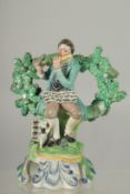 A PRATT WARE BOCAGE GROUP OF A SEATED MAN dog at his side playing a flute. 6ins high.