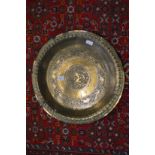 An Eastern brass dish, with engraved decoration.