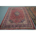 A Persian design carpet, red ground with floral decoration 290cm x 200cm.