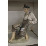A large Royal Copenhagen figure of a fisher boy seated on a rock model no:1659.