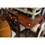 A Victorian walnut extending dining table with one leaf.