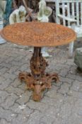 A highly ornate circular cast iron table with ornate base (faults).