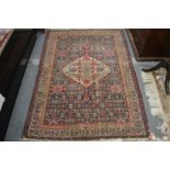 A Persian rug, blue ground with all over stylised decoration (some ware) 190cm x 130cm.