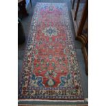 A Persian design runner or hall carpet, red ground with floral decoration 280cm x 100cm.