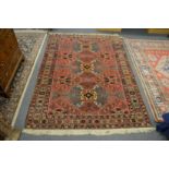 A Persian design rug with pink ground with stylised floral decoration 190cm x 140cm.