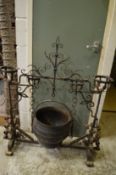 An unusual wrought iron torchere/cooking pot stand.