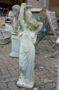 A garden statue modelled as a classical female figure carrying an urn.