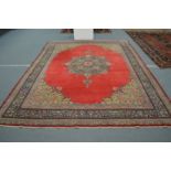 A large Persian design carpet, red ground with floral decoration 360cm x 273cm.