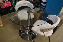 A glass circular table with chrome base together with a pair of armchairs.