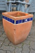 A large square shaped terracotta plant pot.