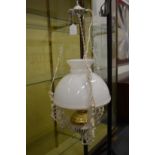 A white painted cast metal hanging lantern with opaque glass shade.