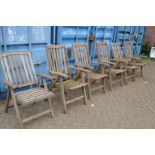 A set of five teak garden reclining armchairs and another similar.