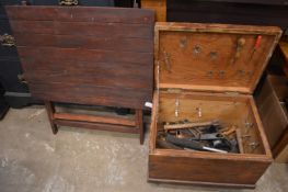 A small pine box containing tools together with a folding table.
