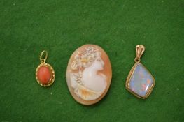A small cameo an opal pendant and a coral pendant.