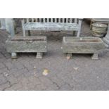 A pair of reconstituted stone rectangular garden troughs on pedestal bases.