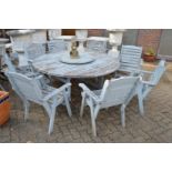 A large painted circular garden table and eight armchairs.