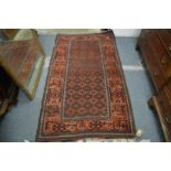 A Persian rug, rust ground with stylised decoration 180cm x 100cm.