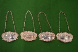 A set of four silver decanter labels.