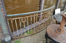 A large curved wrought iron section of a balustrade with copper hand rail.