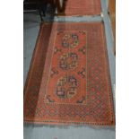 A Persian design rug, red ground with three large central medallions 167cm x 100cm.