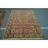 A Persian carpet, pink ground with stylised decoration 215cm x 160cm.