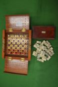 A group of miniature bone dominoes in original box together with a travelling chess set.