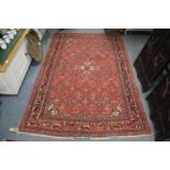 A Persian rug, red ground with all over stylised decoration 210cm x 145cm.