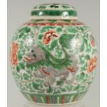 A CHINESE FAMILLE VERTE PORCELAIN JAR AND COVER, painted with foo dogs and large flower heads