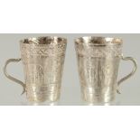 TWO SMALL ETHIOPIAN SILVER CUPS, with engraved decoration, 4.5cm high.