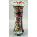 A LARGE JAPANESE IMARI PORCELAIN SLEEVE VASE, painted with a village landscape with panels of