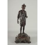 A LARGE INDIAN CARVED HARDWOOD FIGURE, of a man holding a parasol with bone finial, raised and