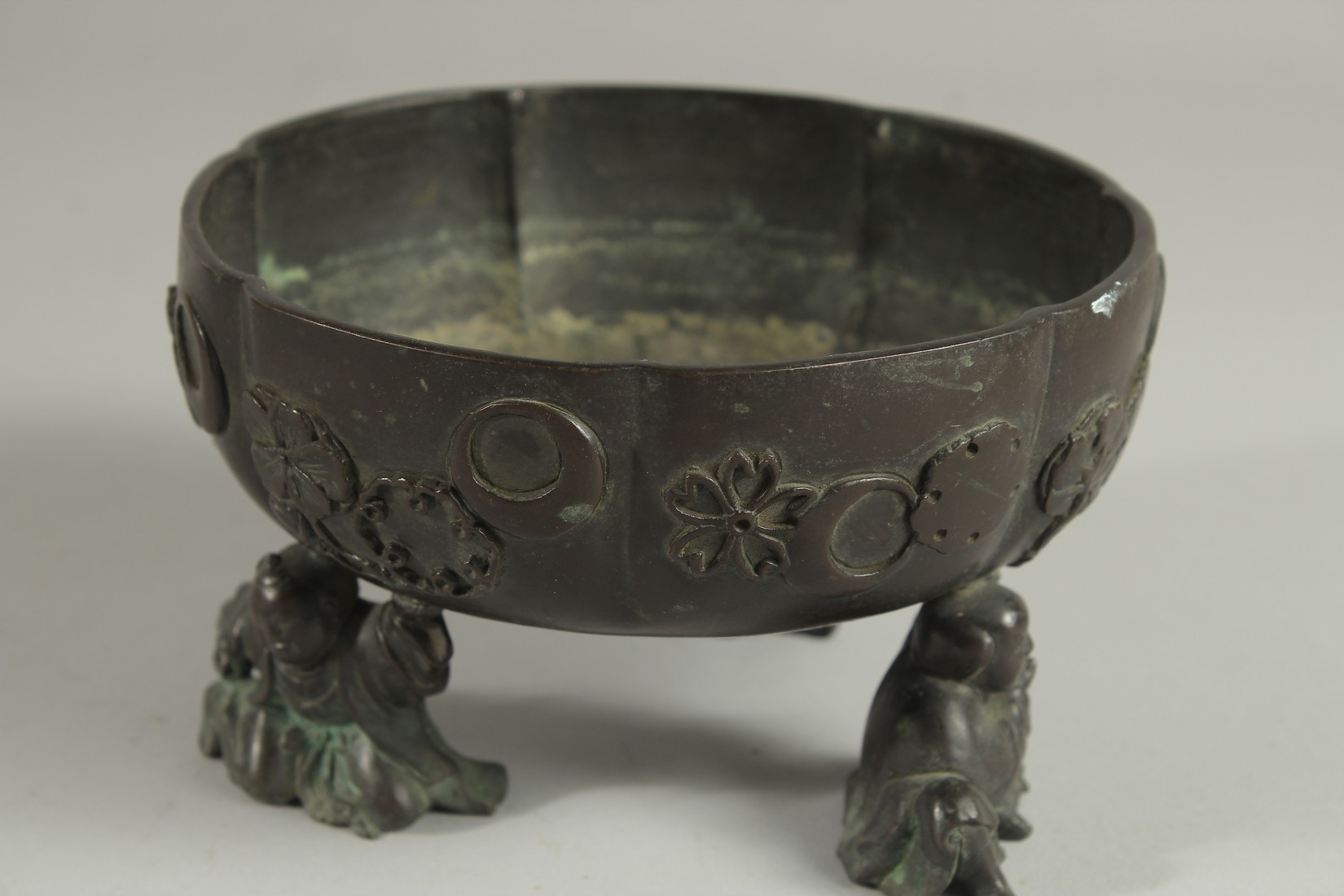 A JAPANESE BRONZE PETAL FORM BOWL, raised on three mounted figural feet, the bowl with relief mon - Image 3 of 5
