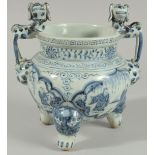 A CHINESE BLUE AND WHITE PORCELAIN TRIPOD CENSER, with moulded dog handles, 20.5cm high.