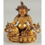 A TIBETAN GILT ALLOY FIGURE OF A SEATED DEITY, 15cm high.