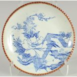 A JAPANESE BLUE AND WHITE IGEZARA PLATE, decorated with flora, 30cm diameter.