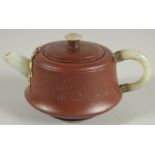 A CHINESE YIXING TEAPOT WITH MOUNDED JADE HANDLE AND SPOUT, with impressed marks to base and inner