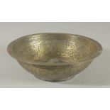 A 19TH CENTURY OTTOMAN BRASS MAGIC BOWL, with engraved calligraphic panels, 20.5cm diameter.