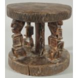 A SMALL AFRICAN DOGON TRIBE CARVED WOODEN STOOL, 18cm high.