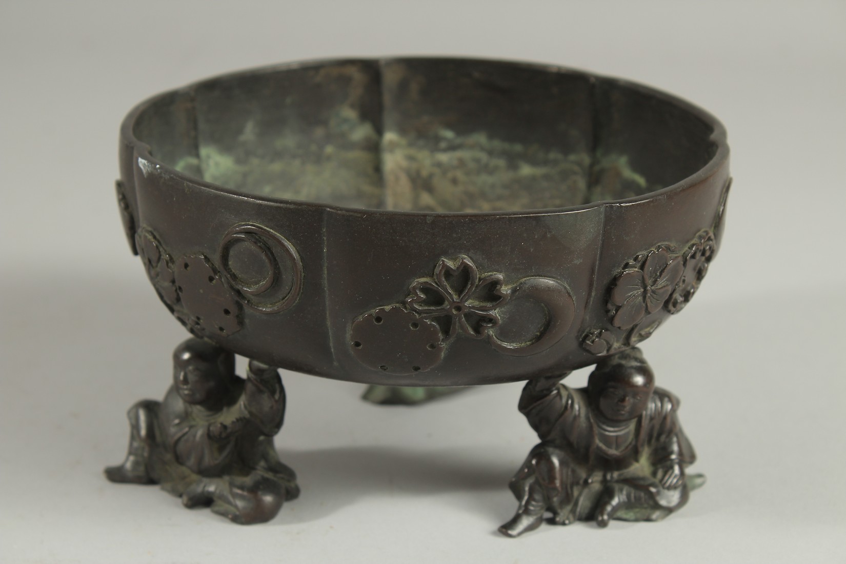 A JAPANESE BRONZE PETAL FORM BOWL, raised on three mounted figural feet, the bowl with relief mon - Image 2 of 5