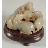 A CHINESE QING DYNASTY CARVED JADE GROUP, depicting three rams, with a fitted hardwood base, jade