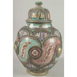 A MOROCCAN METAL MOUNTED POTTERY LIDDED JAR, the jar painted with foliate motifs, 37cm high.