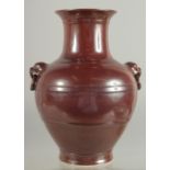 A CHINESE MOTTLED RED GLAZE TWIN HANDLE VASE, with impressed mark to base, 25cm high.