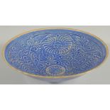 A CHINESE BLUE GROUND CARVED FLORAL BOWL, character mark to base, 20cm diameter.